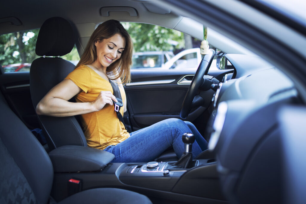 Safety First. Beautiful Female Driver Putting Seat Belt On Before Driving A Car.